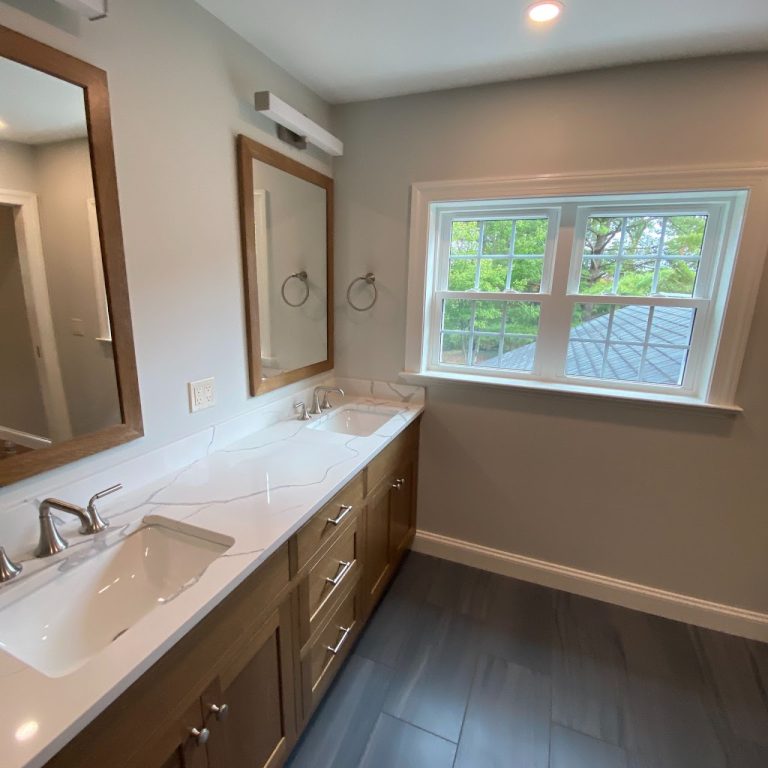 Completed bathroom with double vanity, window and gray tile floor