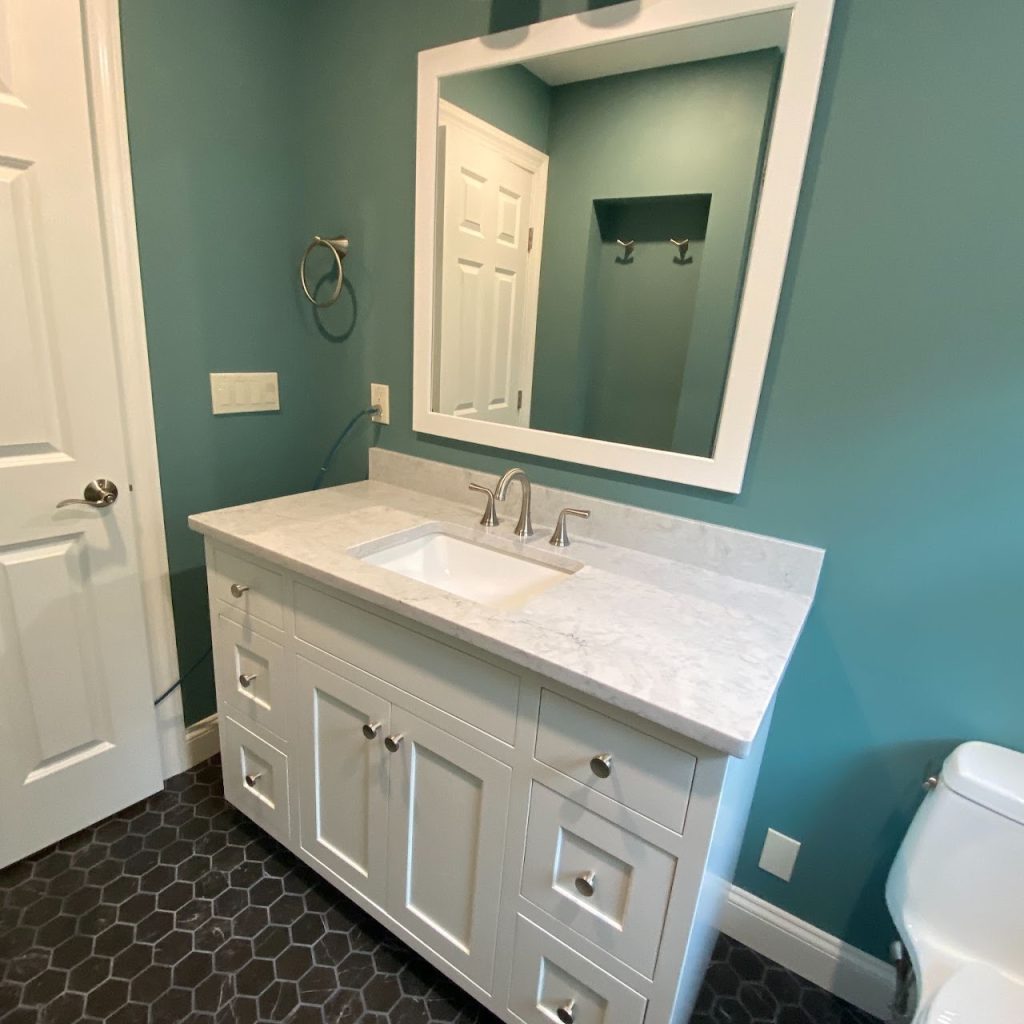 Completed blue bathroom viewed from the doorway with white vanity