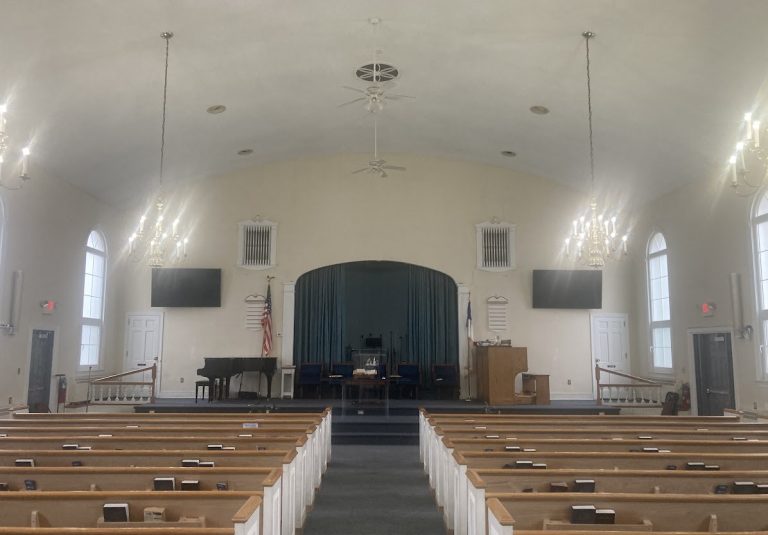 Existing church main hall viewed from the center aisle toward the stage