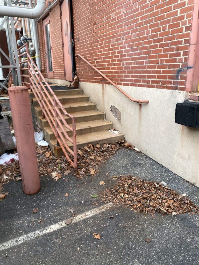 Existing exterior stair and landing at the brick commercial facility