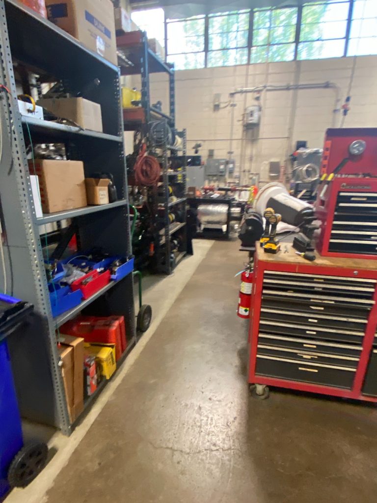 Existing production workspace with equipment, shelving and service utilities