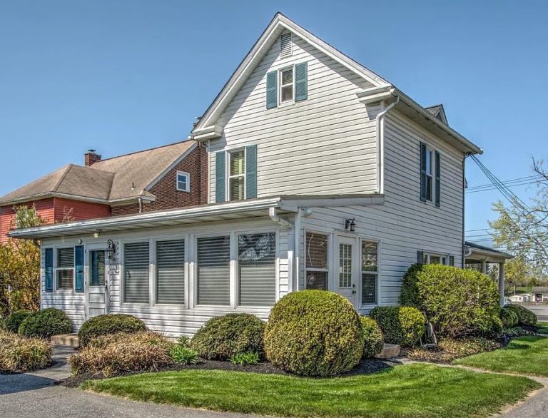 Existing two-story Lancaster office building with white siding and a covered entrance