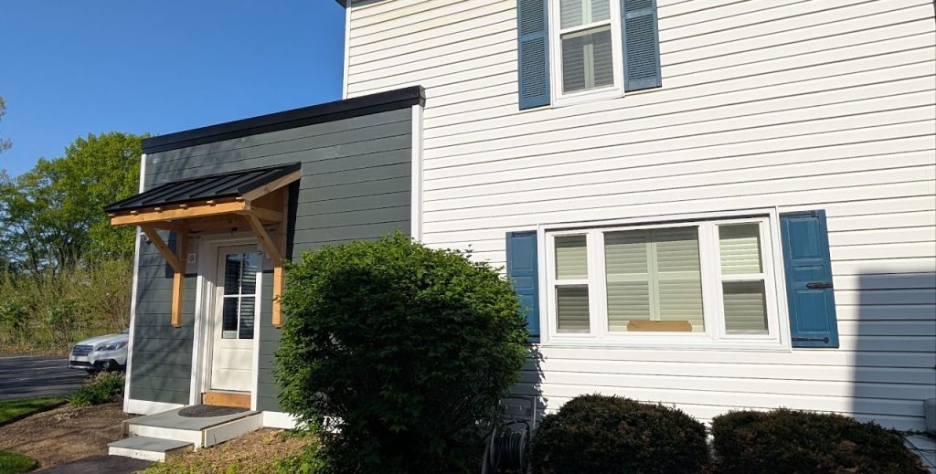 Completed side entrance with timber canopy beside the existing white siding