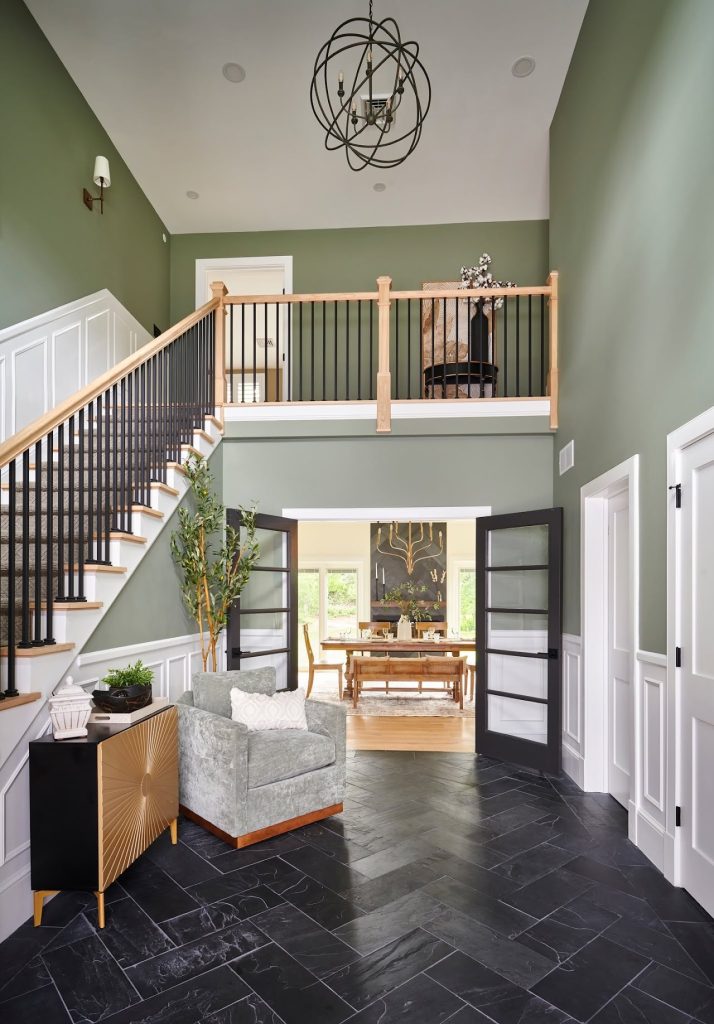 Existing two-story foyer with staircase, balcony and dark tile floor