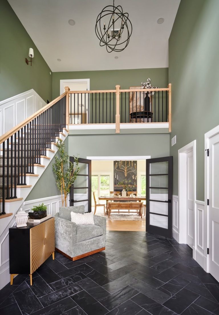Existing two-story foyer with staircase, balcony and dark tile floor