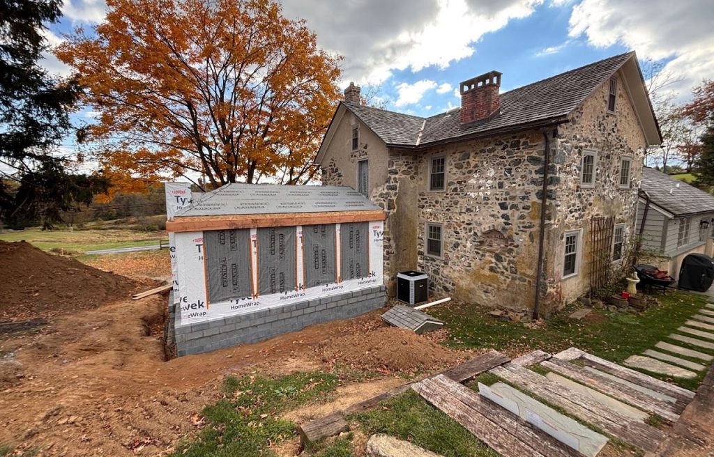 Sunroom addition under construction with foundation walls and framed openings