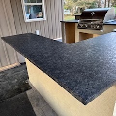 Dark countertop installed on the covered deck outdoor kitchen