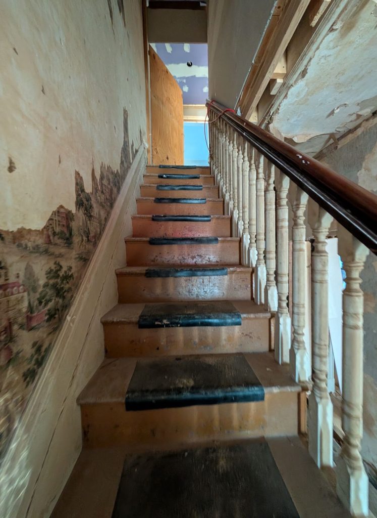 Existing staircase with worn wood treads documented before renovation