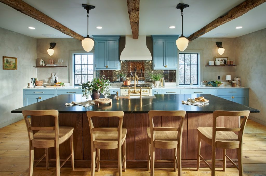 Completed blue kitchen viewed across the wood island and bar seating