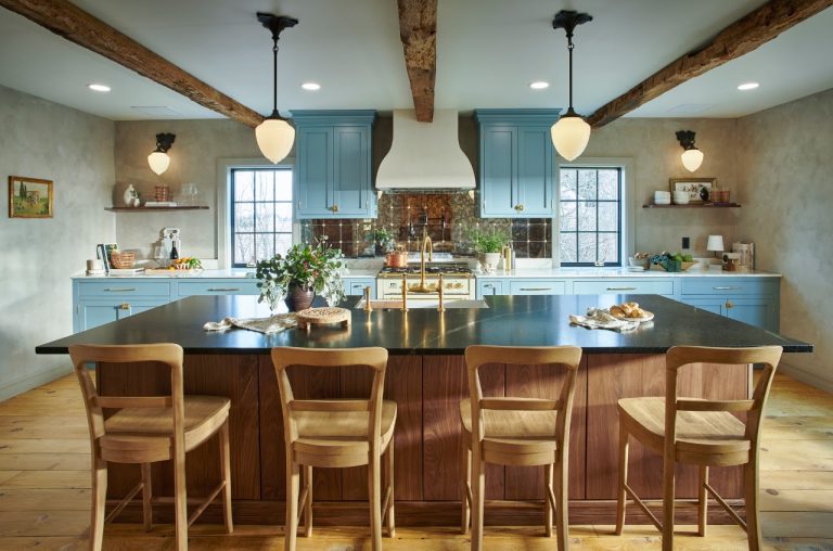 Completed blue kitchen viewed across the wood island and bar seating