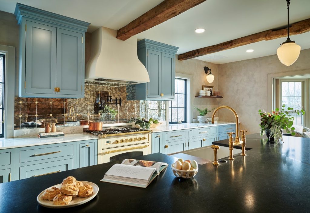 Completed kitchen showing the blue cabinetry, range wall and black island countertop