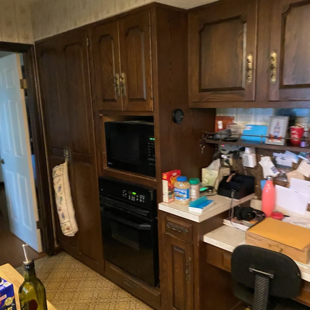 Existing kitchen wall with dark wood oven cabinet and countertop