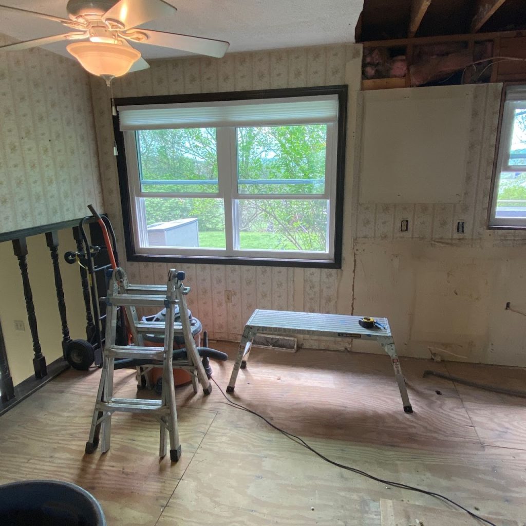Kitchen demolition progress with cabinets removed beneath the window