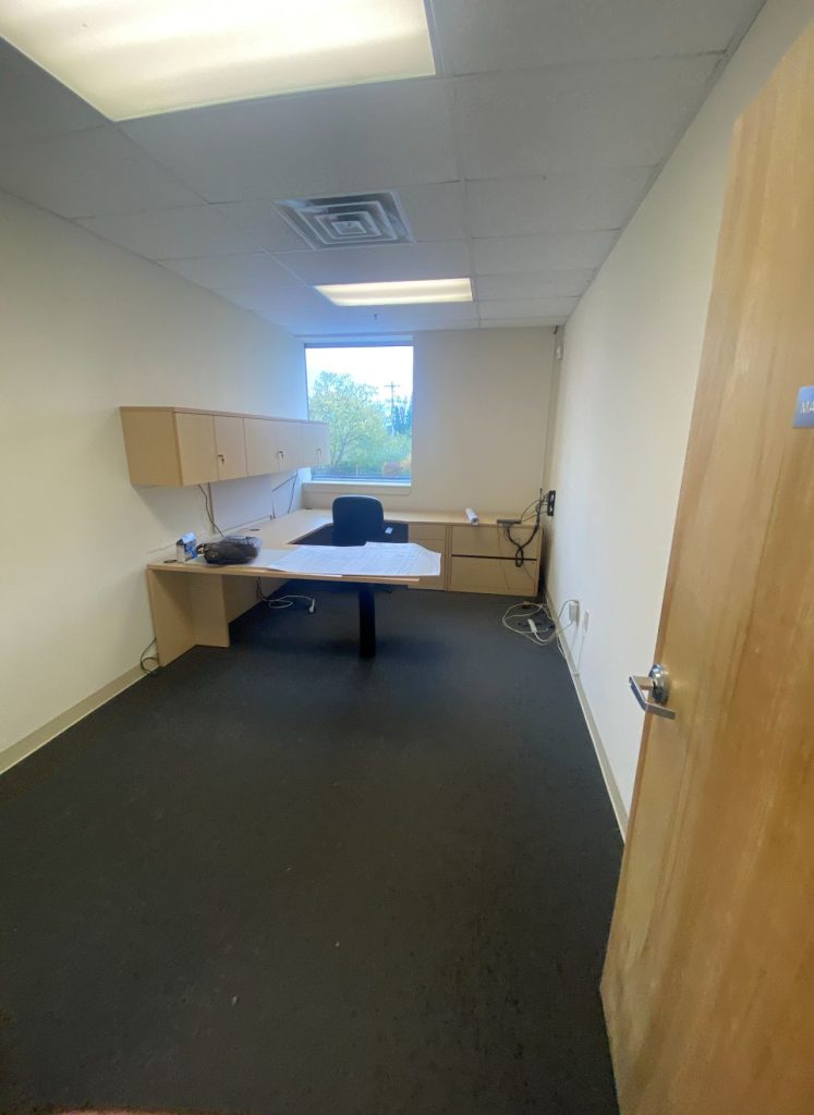 Existing private office with desk, wall cabinets and carpet flooring