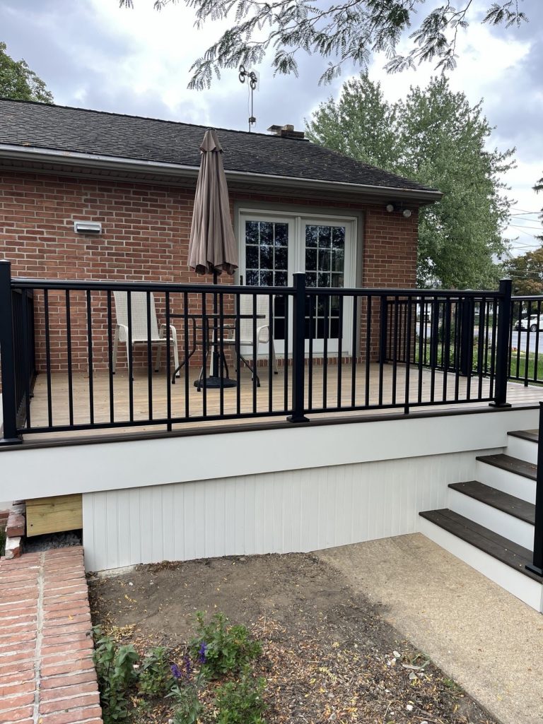 Completed rear porch with composite decking, black railing and stairs