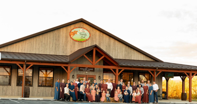 Photograph of the completed Family Cow building with a group gathered in front of the main entrance.